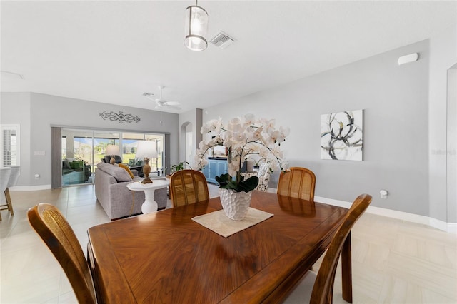 dining room featuring visible vents, arched walkways, baseboards, and ceiling fan