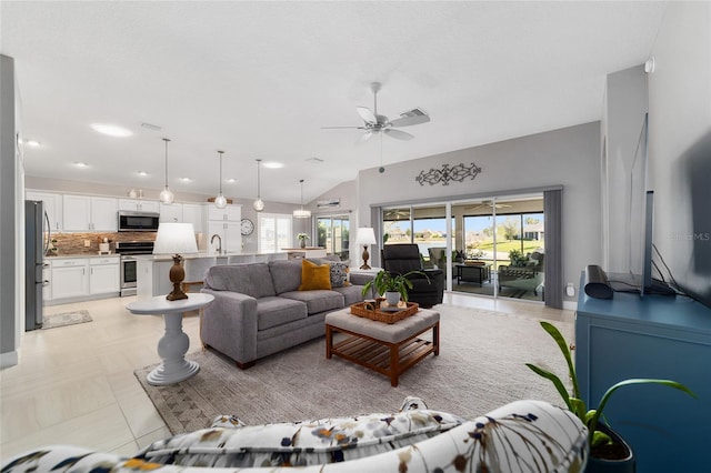 living room with vaulted ceiling, light tile patterned flooring, and a ceiling fan