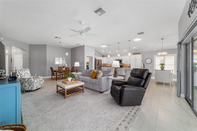 living area featuring visible vents, arched walkways, baseboards, and vaulted ceiling