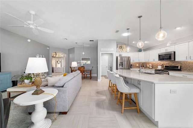 living room with lofted ceiling, visible vents, and ceiling fan