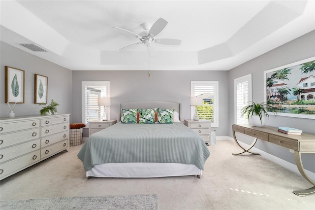 bedroom featuring visible vents, ceiling fan, baseboards, light carpet, and a raised ceiling