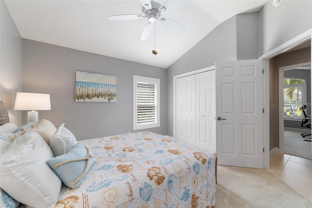 bedroom featuring a closet, light colored carpet, a ceiling fan, and vaulted ceiling