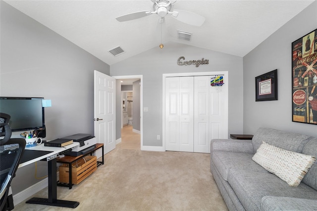 office space with visible vents, light carpet, a ceiling fan, and vaulted ceiling