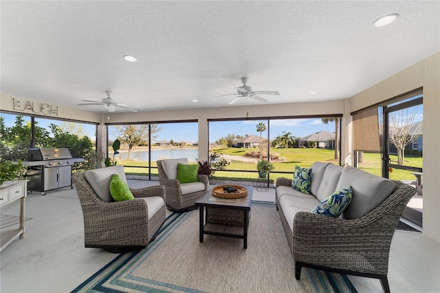 sunroom / solarium featuring a water view and ceiling fan