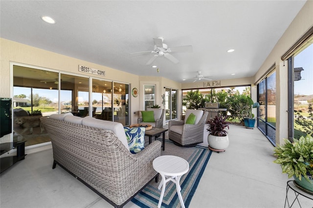 sunroom / solarium featuring a healthy amount of sunlight and a ceiling fan