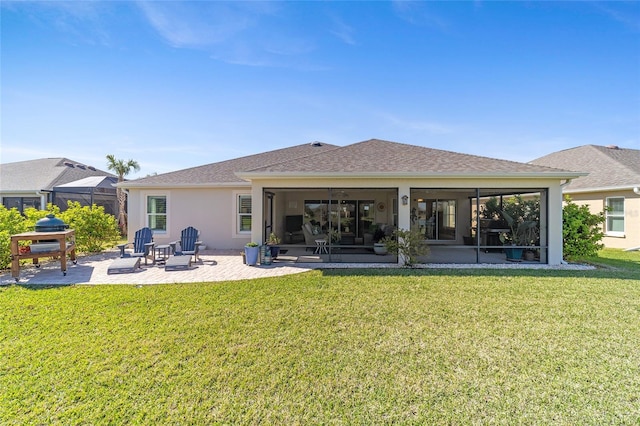 rear view of property featuring a yard, a patio area, a sunroom, and stucco siding