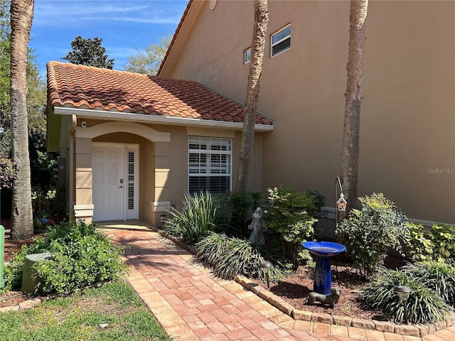 property entrance featuring stucco siding and a tiled roof