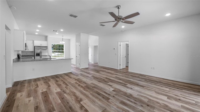 unfurnished living room with recessed lighting, wood finished floors, visible vents, and a sink