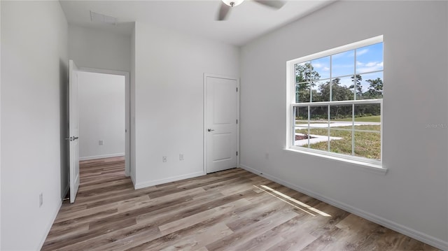 unfurnished bedroom featuring visible vents, baseboards, wood finished floors, and a ceiling fan