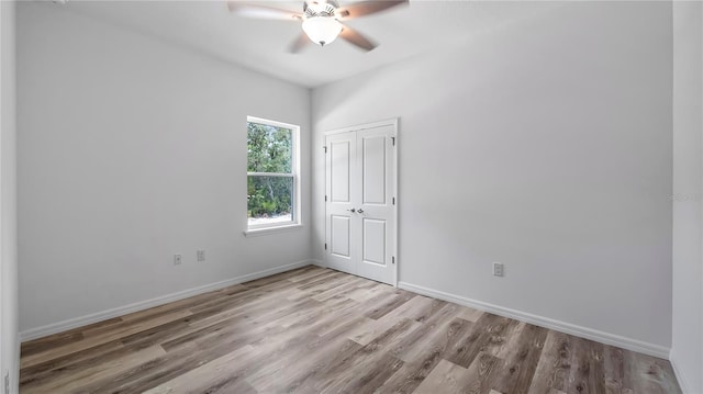 empty room with ceiling fan, baseboards, and wood finished floors