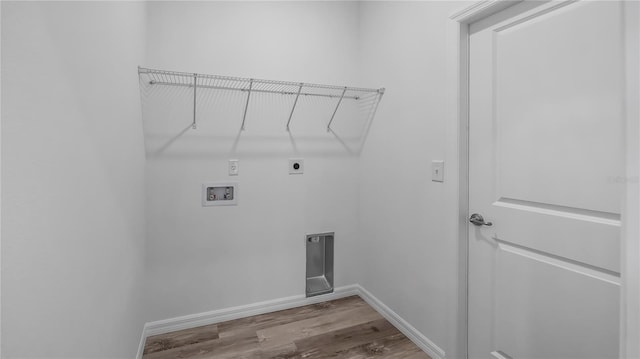 washroom featuring electric dryer hookup, wood finished floors, baseboards, hookup for a washing machine, and laundry area