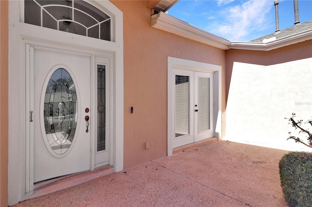 property entrance featuring french doors and stucco siding