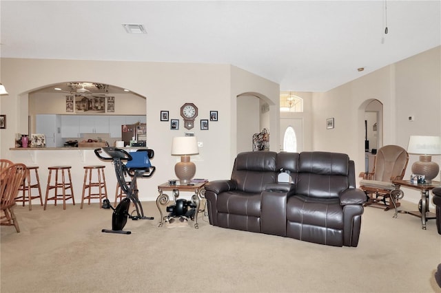 living room featuring arched walkways, visible vents, and carpet floors