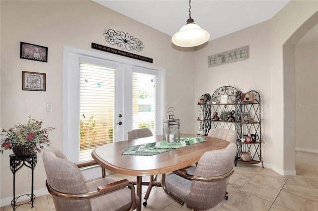 dining area with arched walkways, french doors, and baseboards