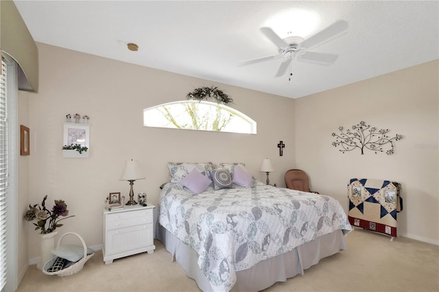 bedroom featuring light colored carpet, baseboards, and ceiling fan