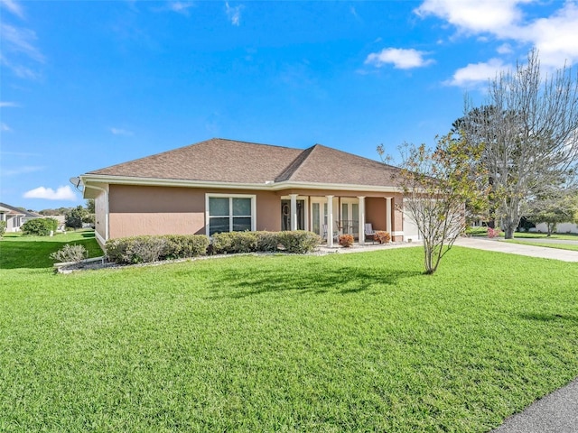 view of front of property featuring stucco siding, a front lawn, concrete driveway, an attached garage, and a shingled roof