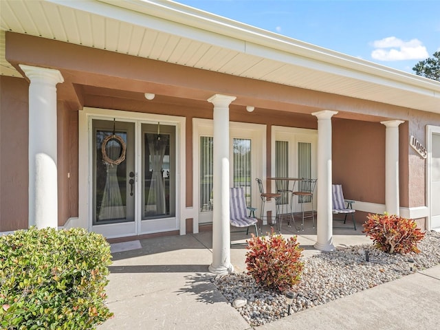 entrance to property featuring a porch and french doors