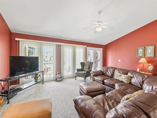 living room with a ceiling fan, carpet floors, vaulted ceiling, french doors, and a textured ceiling