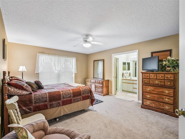 bedroom with connected bathroom, carpet, a ceiling fan, and a textured ceiling