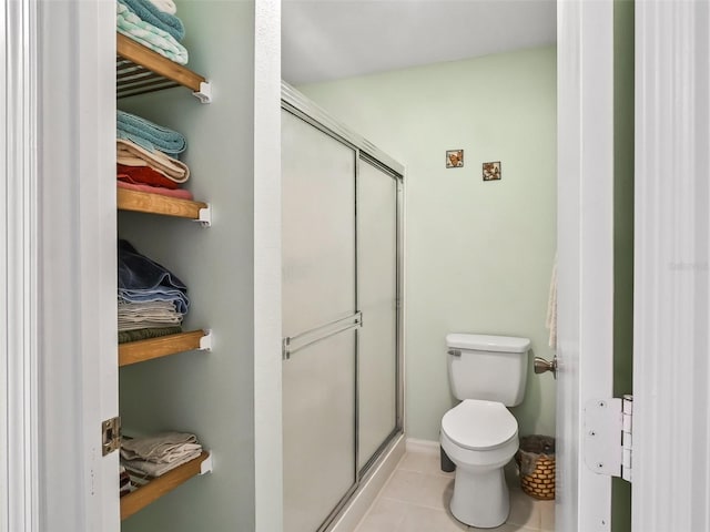 full bath with tile patterned flooring, a stall shower, and toilet