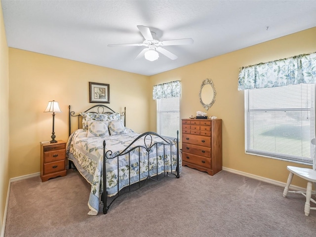 carpeted bedroom with baseboards, multiple windows, and ceiling fan