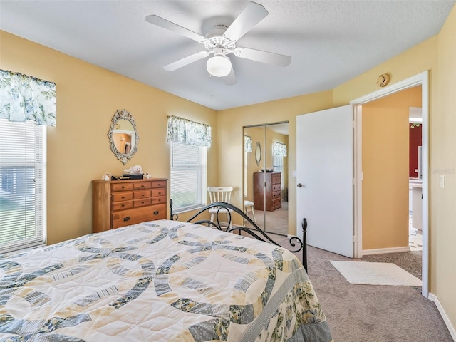 carpeted bedroom featuring a closet, baseboards, and ceiling fan