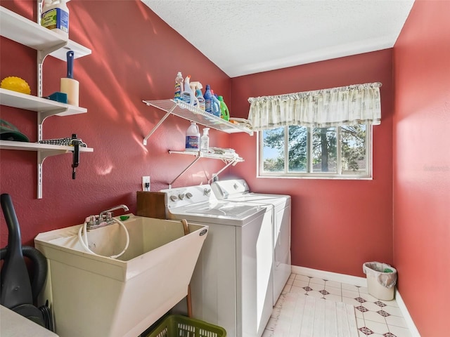 laundry room featuring baseboards, laundry area, a sink, tile patterned floors, and washer and clothes dryer