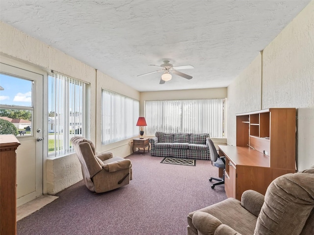 interior space featuring a textured ceiling, a ceiling fan, and a textured wall