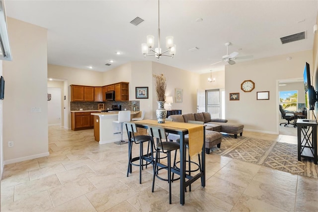 dining room with visible vents, ceiling fan with notable chandelier, and baseboards