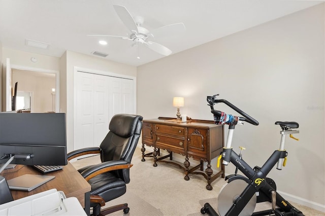 home office with visible vents, light colored carpet, baseboards, and a ceiling fan