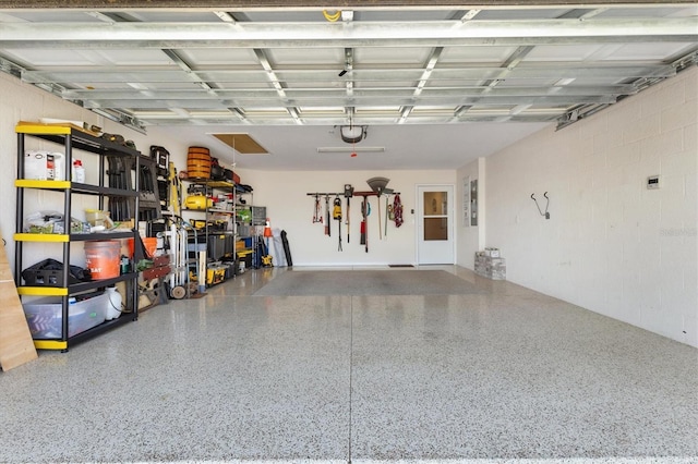 garage featuring a garage door opener and concrete block wall