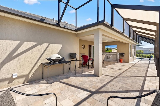 view of patio / terrace with an outdoor kitchen and a lanai