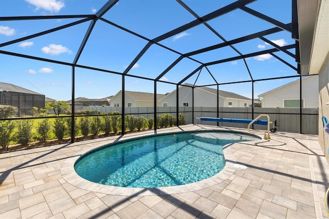 view of pool with a patio area, a residential view, a fenced in pool, and a lanai