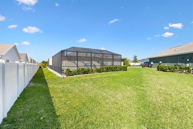 view of yard featuring glass enclosure and fence