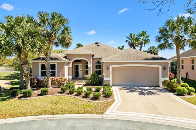 view of front of property featuring stucco siding, an attached garage, driveway, and a front lawn