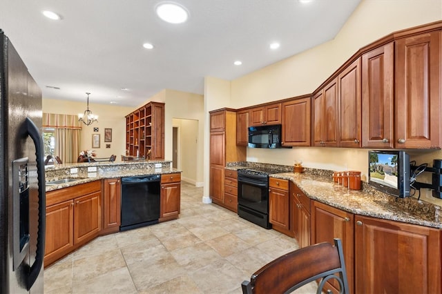 kitchen with black appliances, brown cabinets, stone counters, and a sink