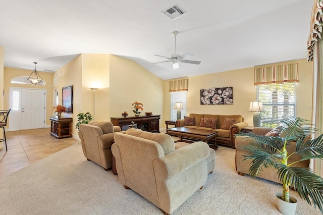 living room featuring visible vents, a ceiling fan, light tile patterned flooring, light colored carpet, and vaulted ceiling