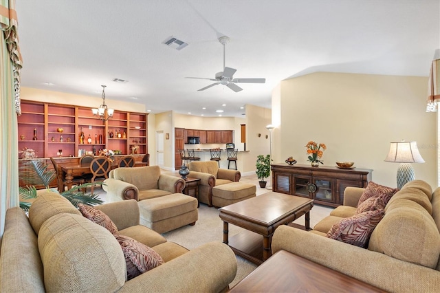 living room featuring baseboards, ceiling fan with notable chandelier, visible vents, and light carpet