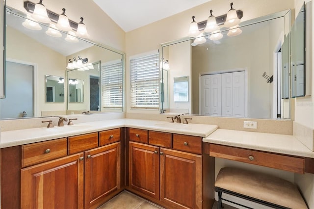 full bathroom with tile patterned flooring, double vanity, vaulted ceiling, and a sink