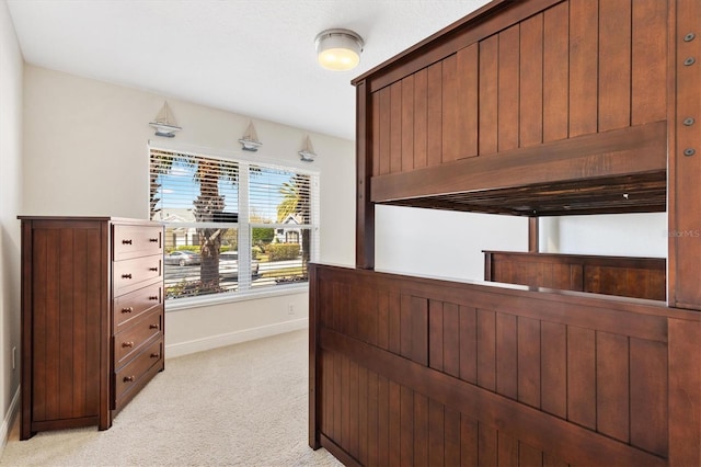 bedroom with light colored carpet and baseboards