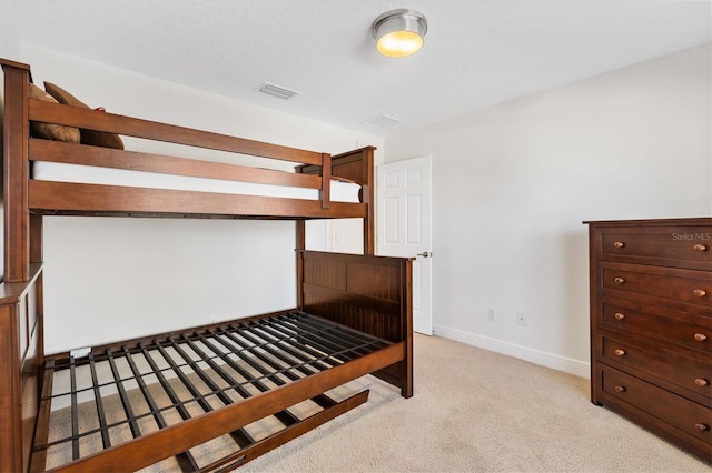 bedroom with visible vents, light carpet, and baseboards