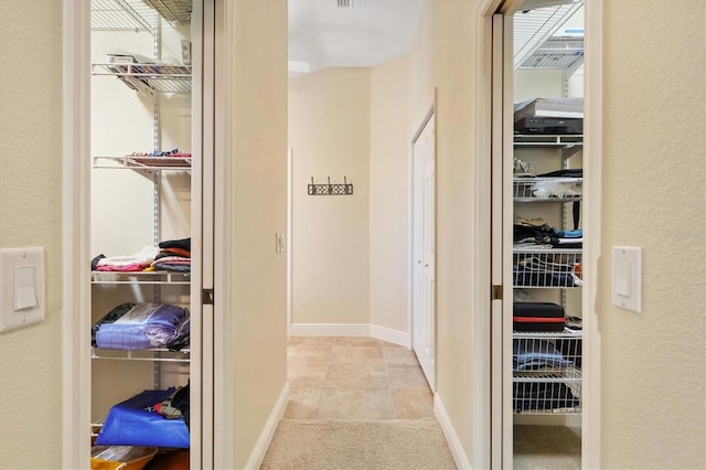 hall featuring tile patterned flooring and baseboards