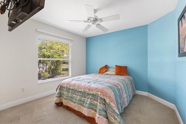 bedroom featuring baseboards, carpet floors, ceiling fan, an AC wall unit, and a textured ceiling