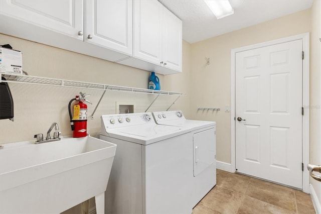 washroom with cabinet space, independent washer and dryer, and a sink