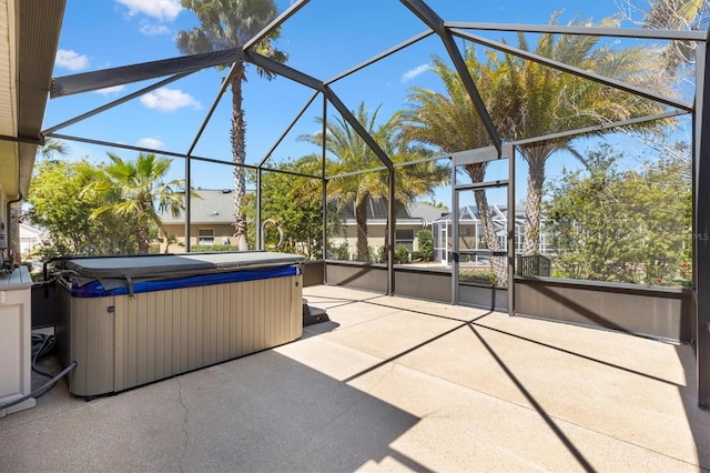 view of patio with glass enclosure and a hot tub