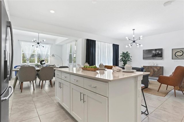 kitchen featuring a kitchen island, a notable chandelier, light tile patterned flooring, and stainless steel fridge with ice dispenser