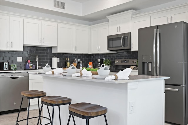 kitchen with white cabinetry, a sink, backsplash, and stainless steel appliances