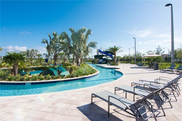 pool featuring a patio and a water slide