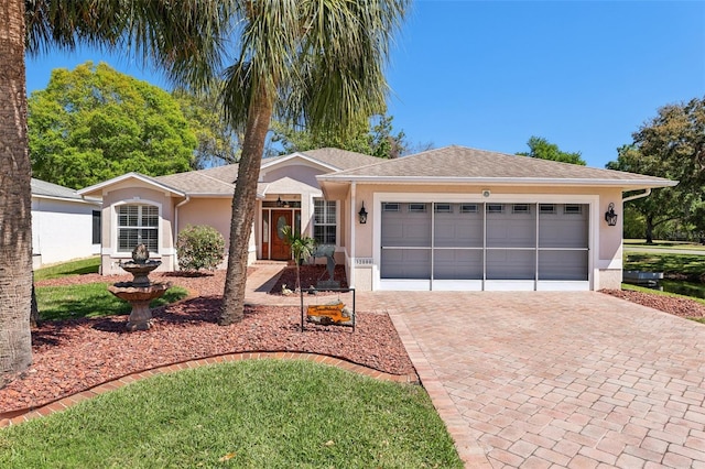 single story home featuring decorative driveway, a garage, roof with shingles, and stucco siding