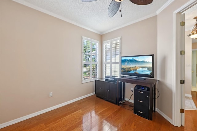 office area featuring baseboards, ornamental molding, wood finished floors, a textured ceiling, and a ceiling fan